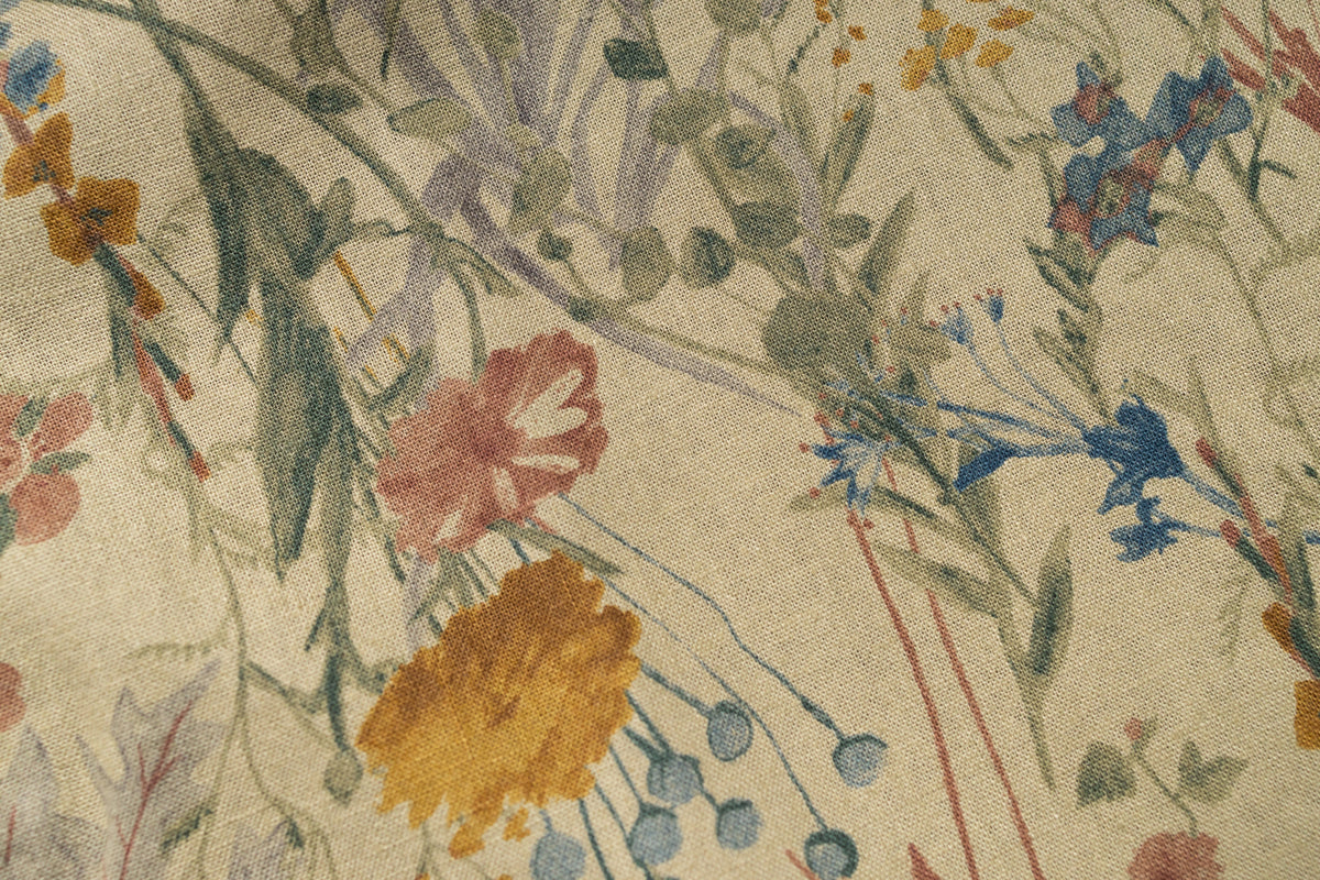 Close-up of a floral patterned fabric with various colors on a beige background