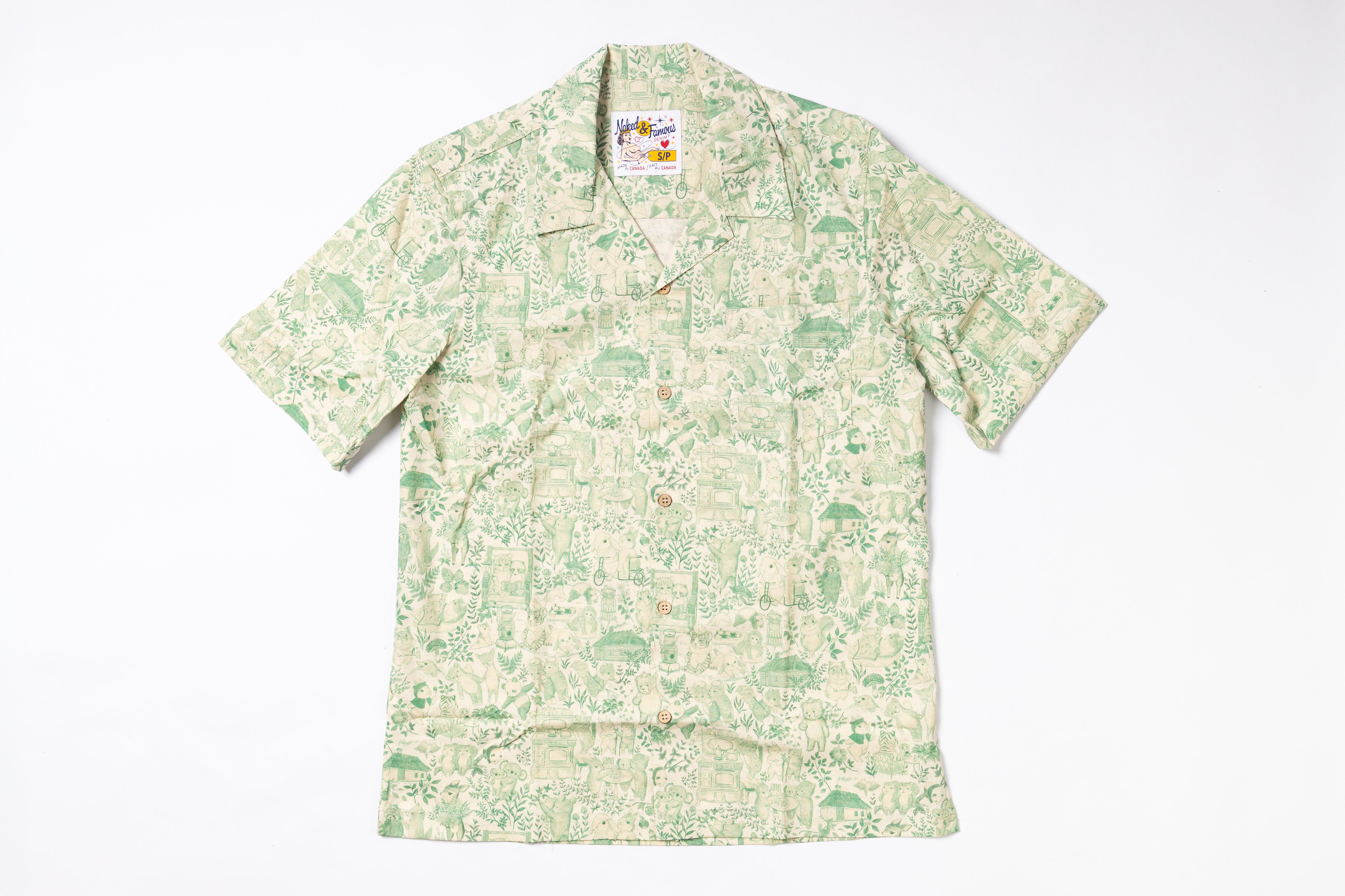 A short-sleeve button-up camp shirt with a light green and beige tropical landscape print, laid flat against a white background.