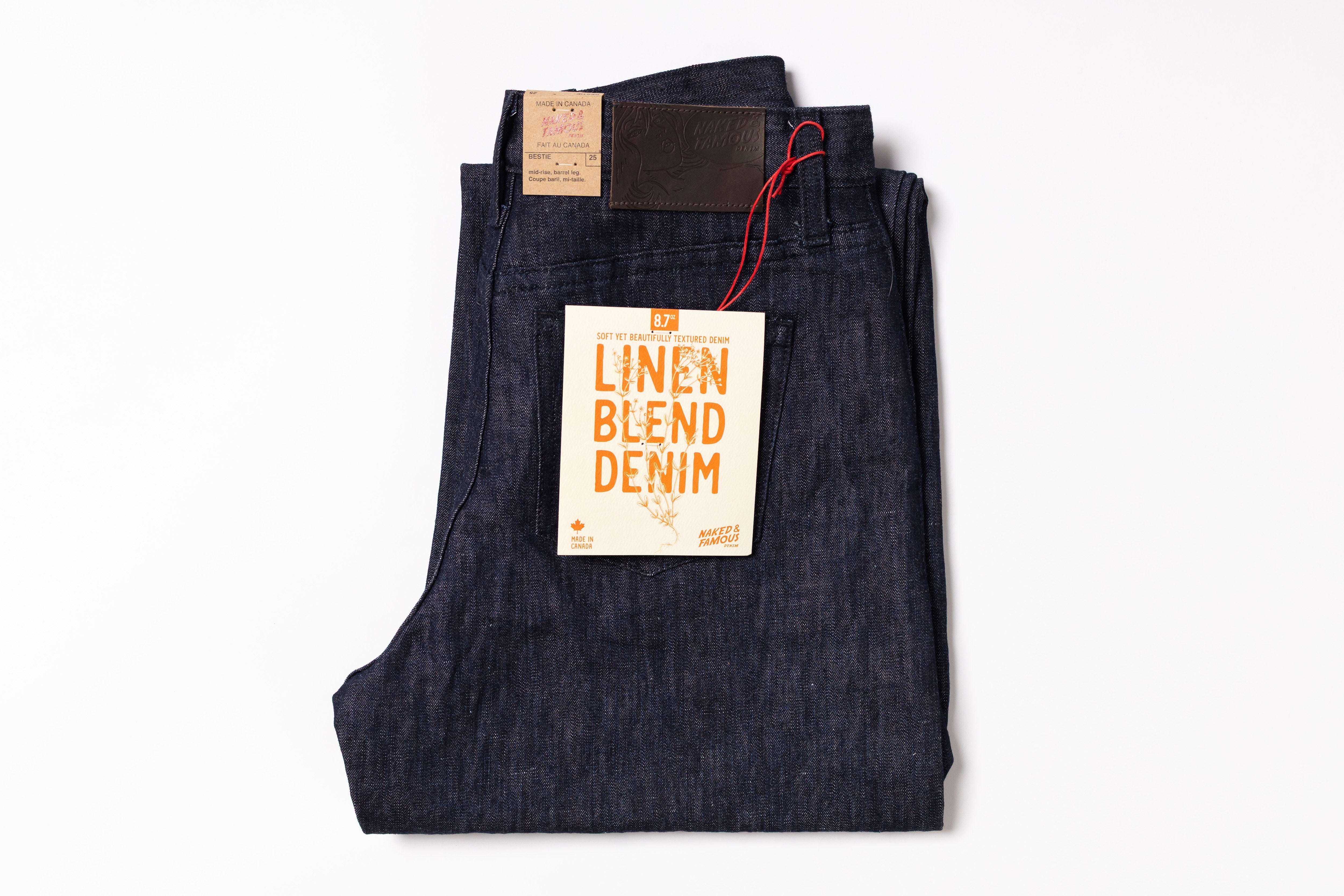 Folded linen blend denim jeans with a tag on a white background