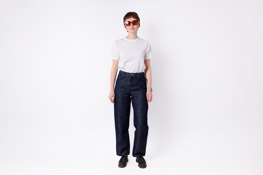 Person wearing dark blue jeans and a white shirt on a white background
