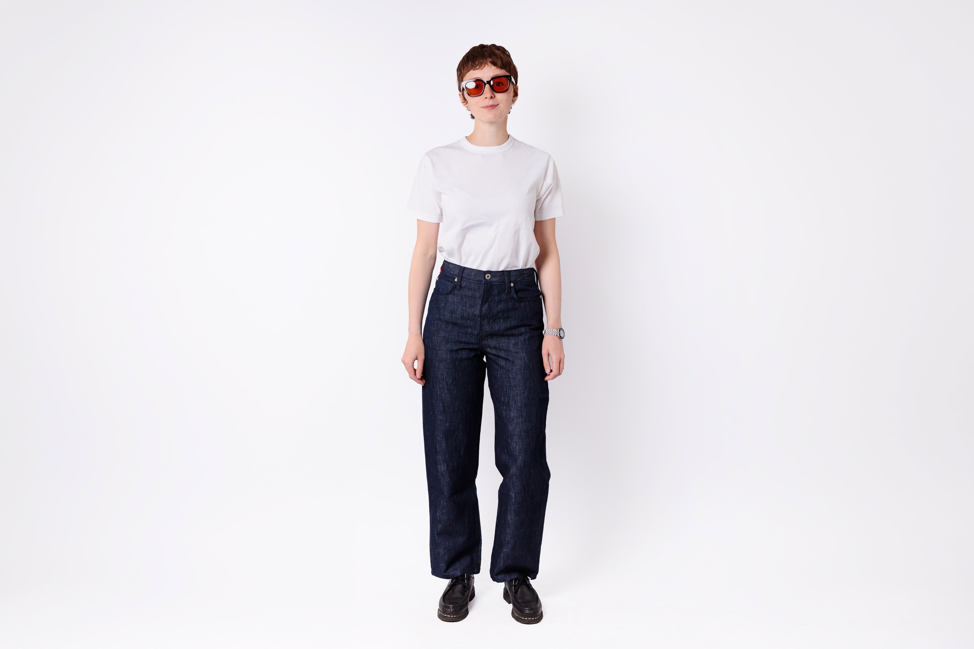 Person wearing dark blue jeans and a white shirt on a white background