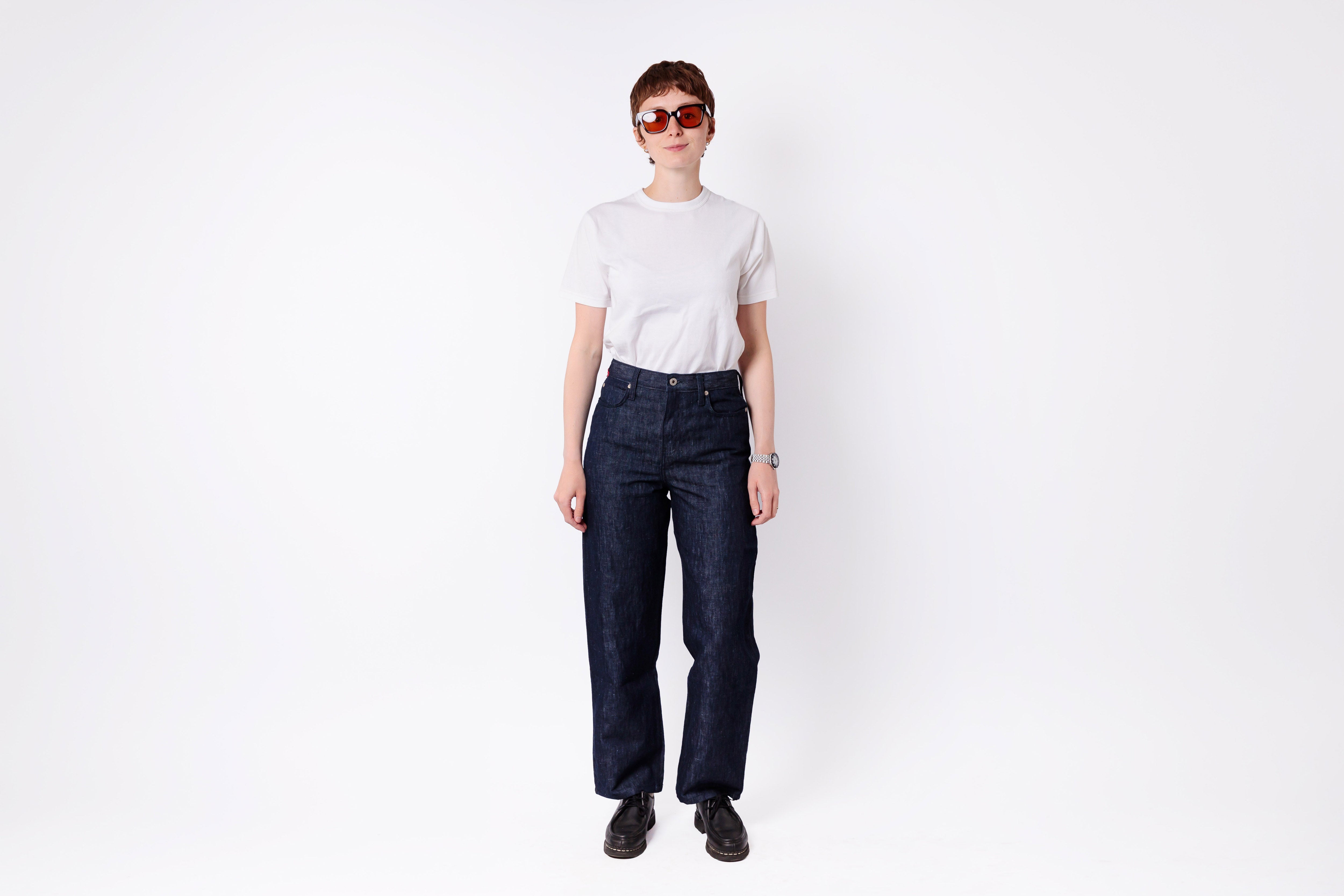 Person wearing dark blue jeans and a white shirt on a white background