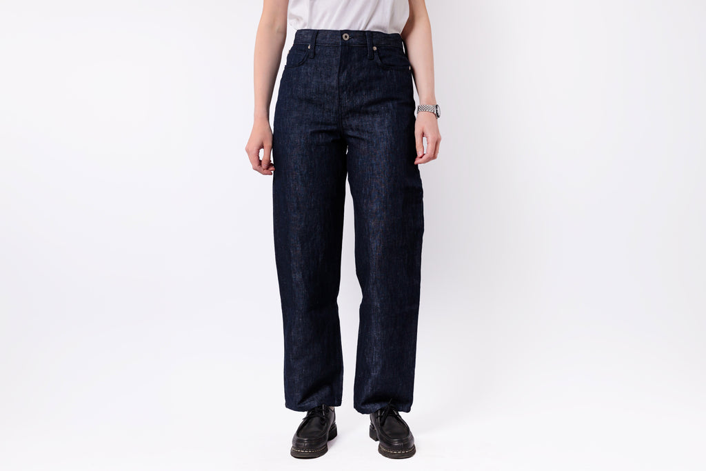 Person wearing dark blue jeans on a white background