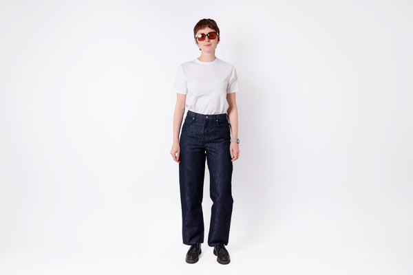 Person wearing dark blue jeans and a white shirt on a white background
