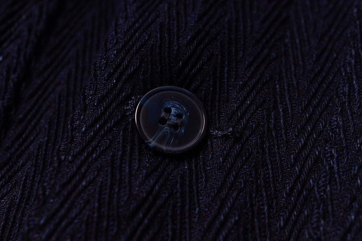 Close-up of a button on dark textured fabric