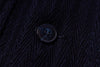 Close-up of a button on dark textured fabric