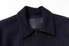 Close-up of a dark blue garment with a brand label on a white background