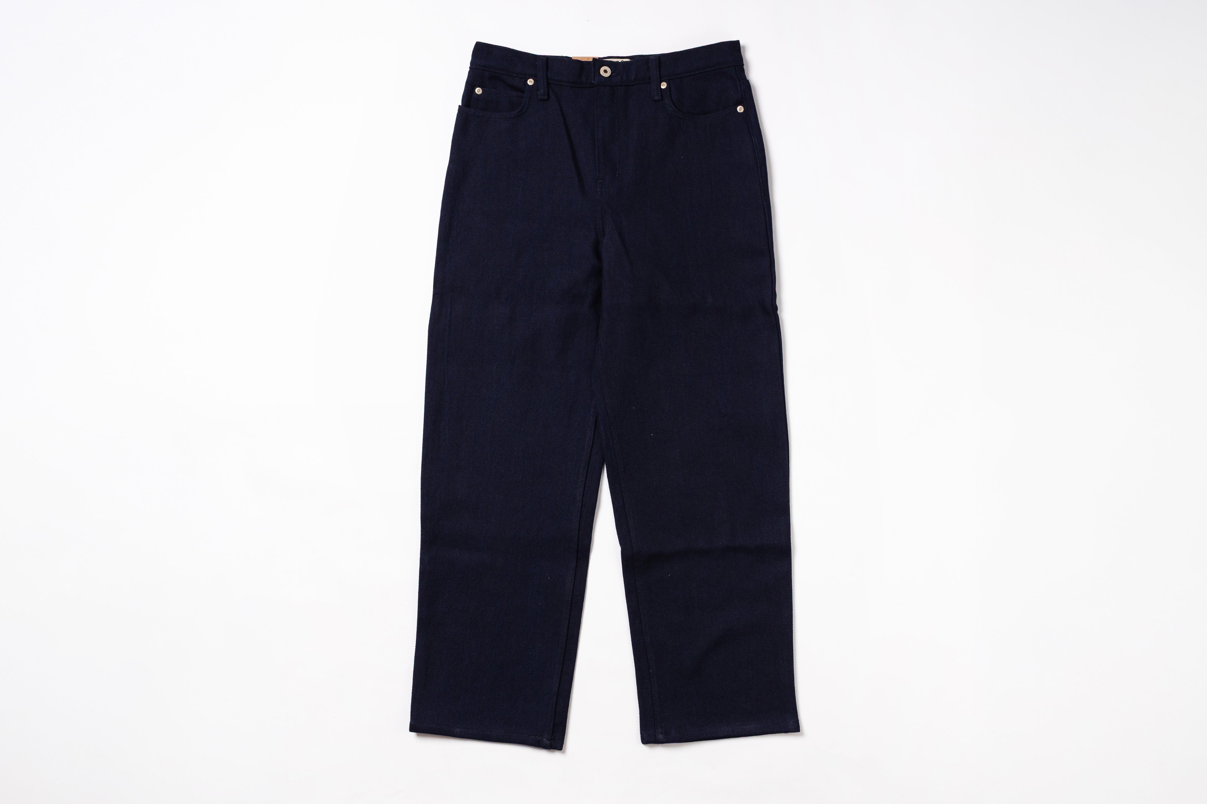 A pair of dark navy blue denim pants laid flat against a solid white background.