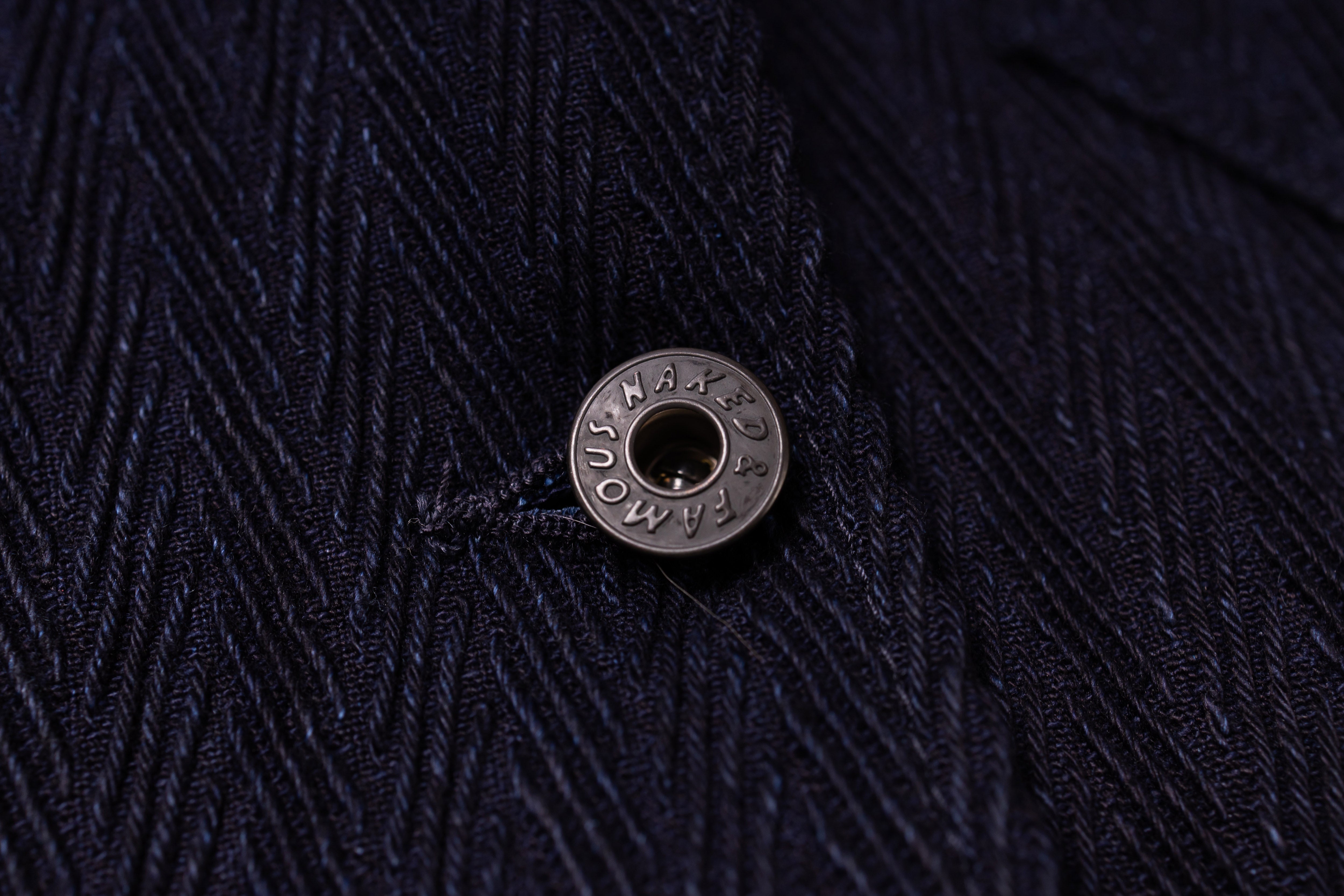 Close-up of a textured dark fabric with a button featuring visible branding.