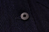 Close-up of a textured dark fabric with a button featuring visible branding.