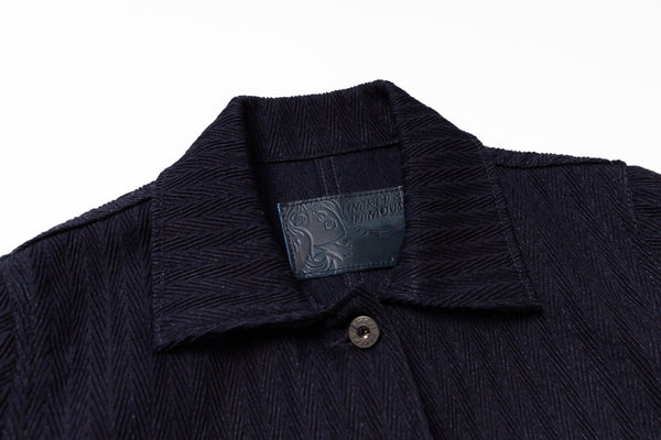 Close-up of a dark blue garment with a brand label on a white background
