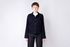 Person wearing a dark jacket and jeans on a white background
