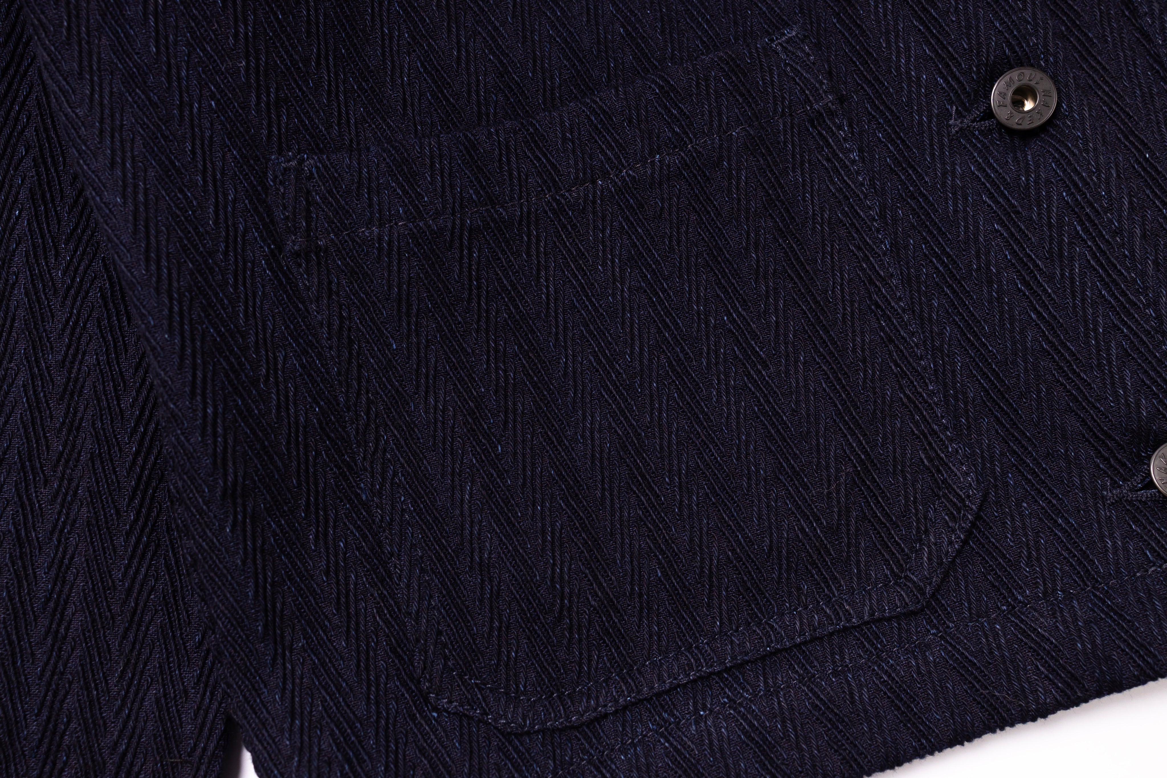 Close-up of a dark blue textured fabric with a button on a white background