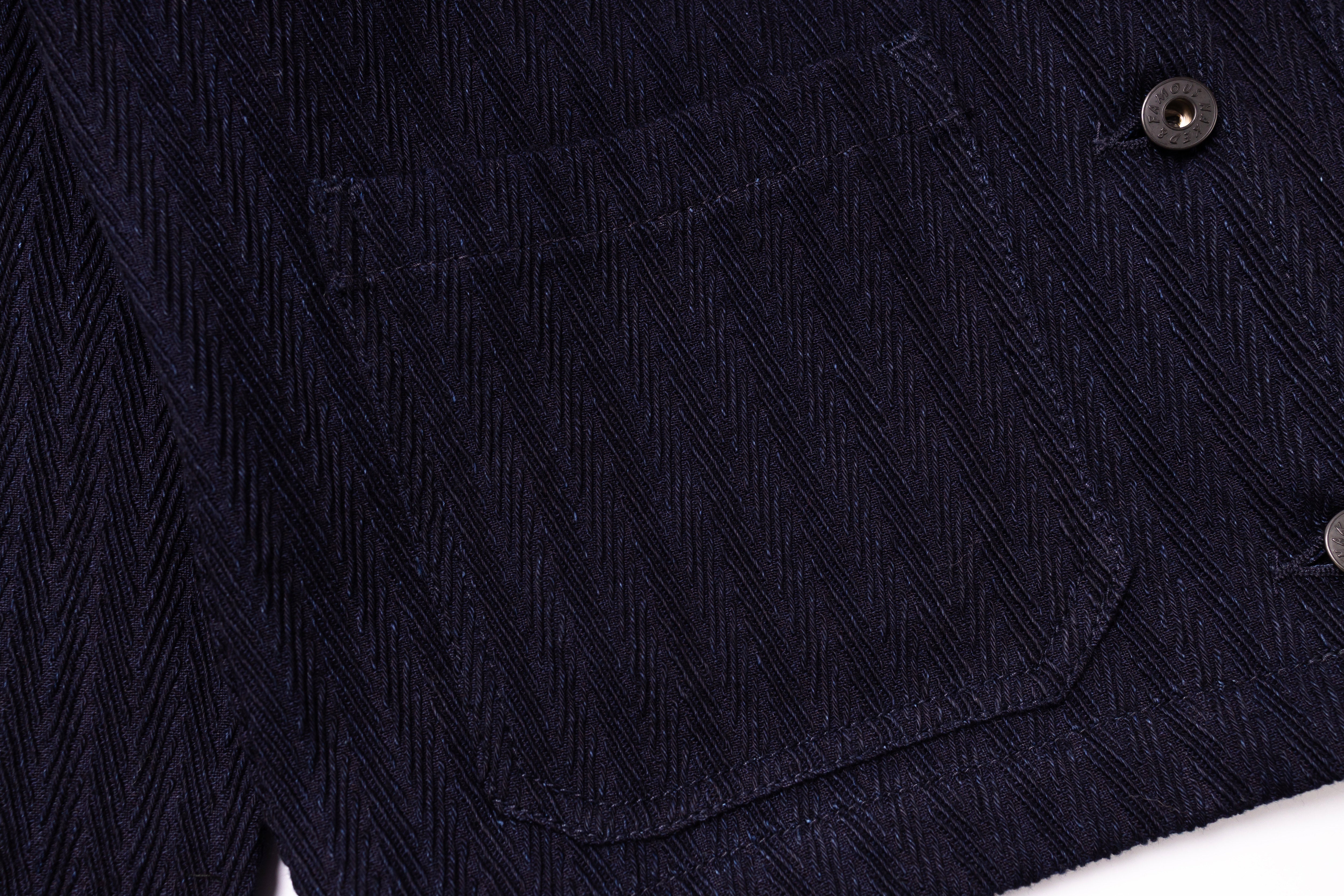 Close-up of a dark blue textured fabric with a button on a white background
