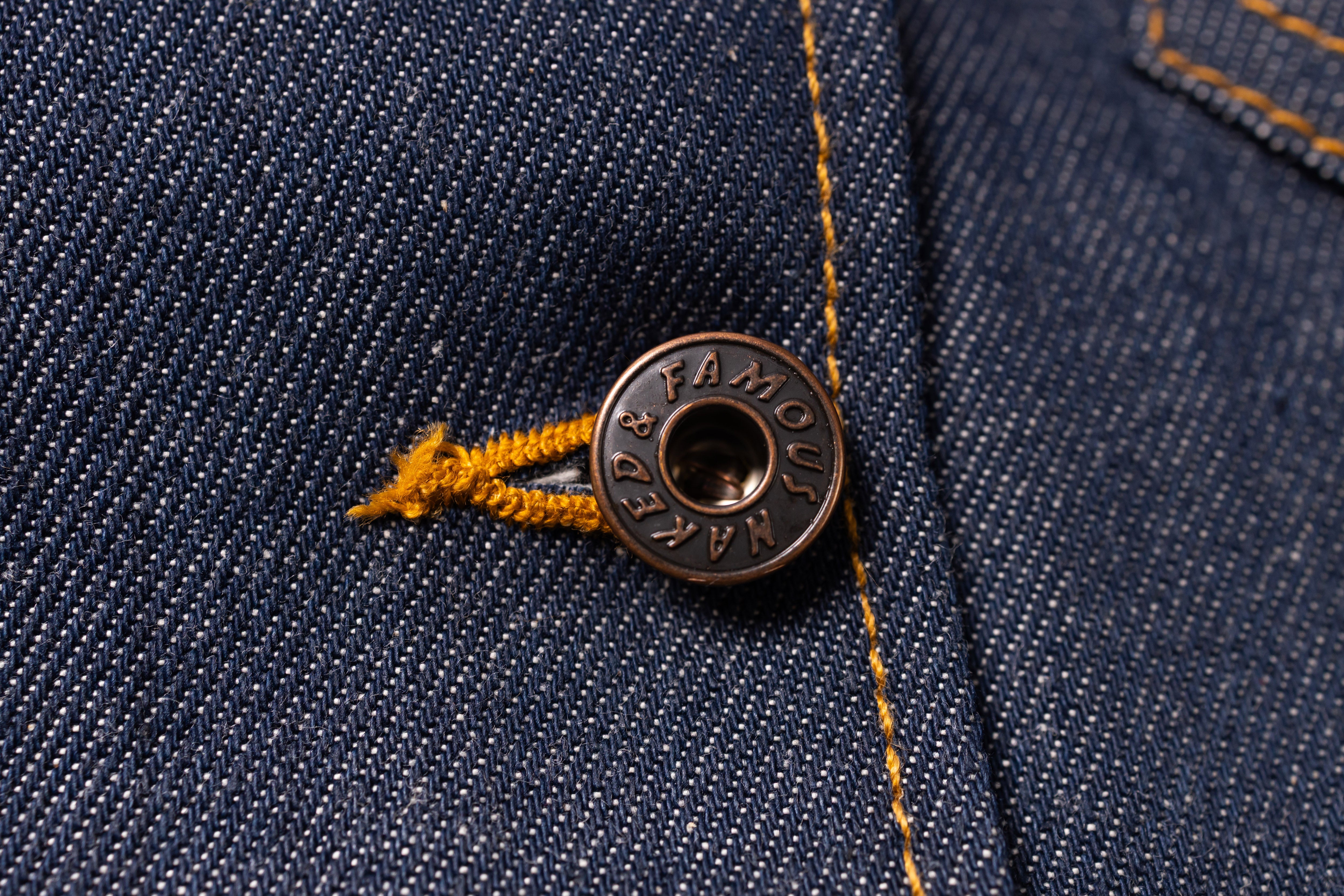 Close-up of a button on denim fabric.