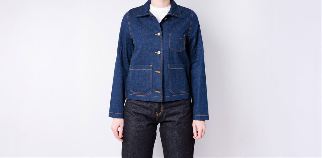 Person wearing a blue denim jacket on a white background
