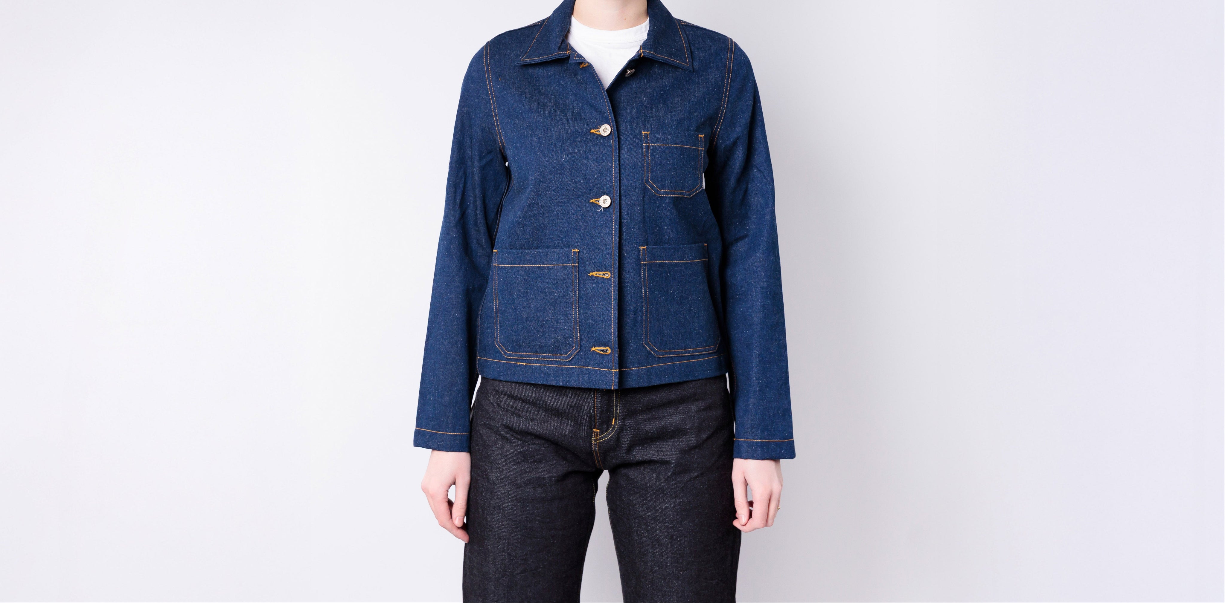 Person wearing a blue denim jacket on a white background