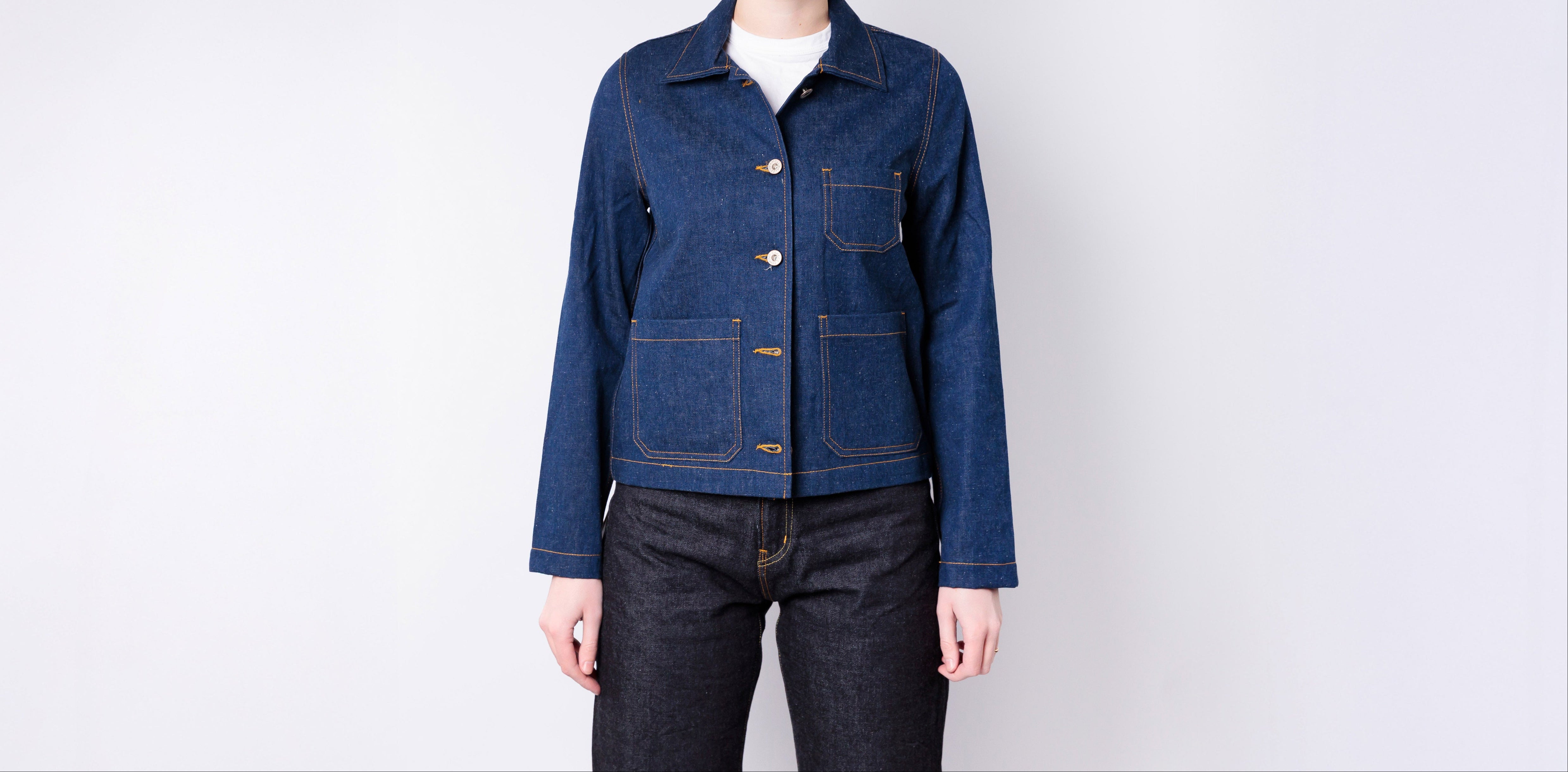 Person wearing a blue denim jacket on a white background