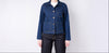 Person wearing a blue denim jacket on a white background