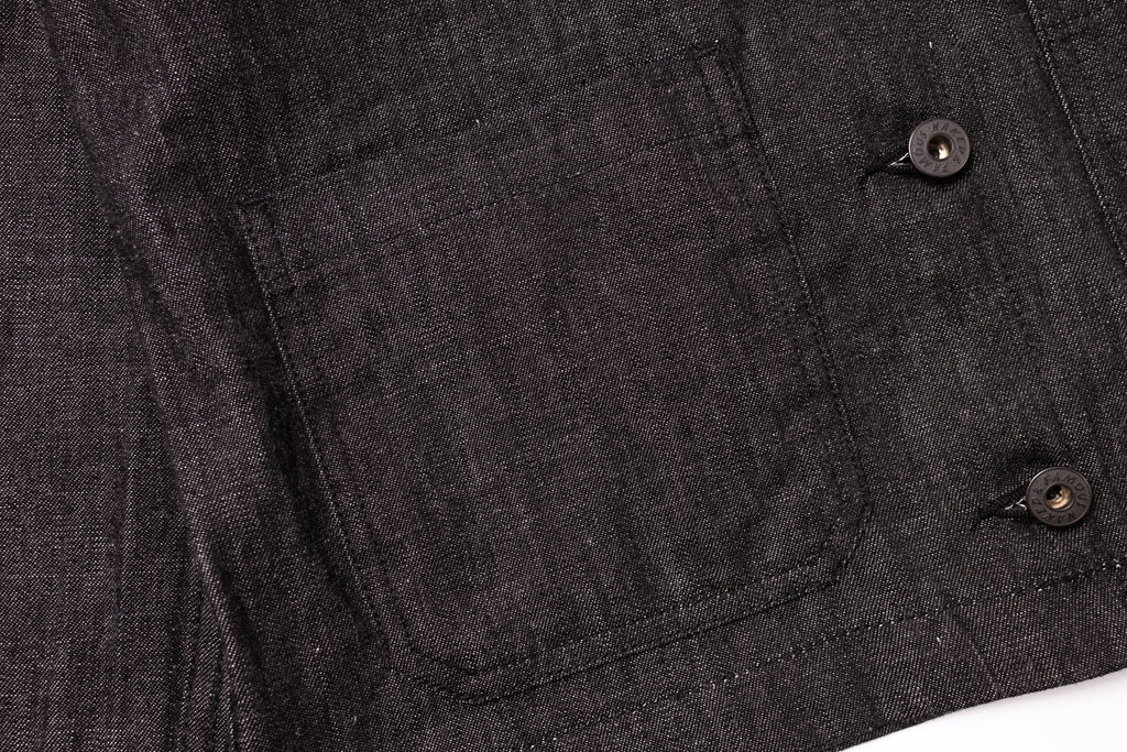 Close-up of a dark gray fabric with button details on a white background