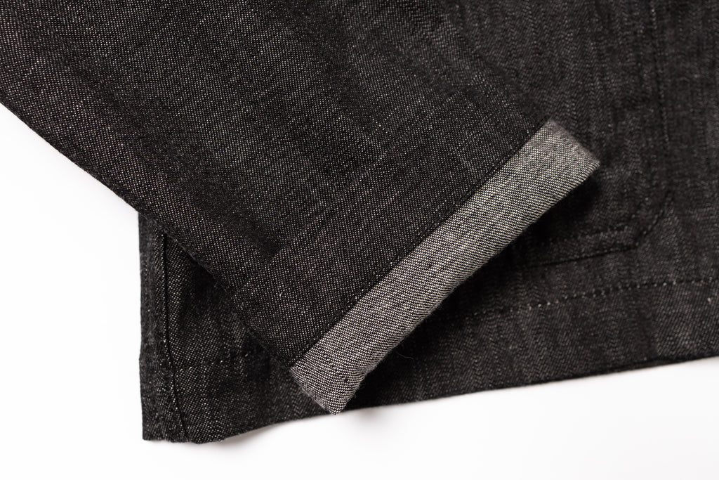 Close-up of dark gray fabric with a seam on a white background