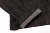 Close-up of dark gray fabric with a seam on a white background