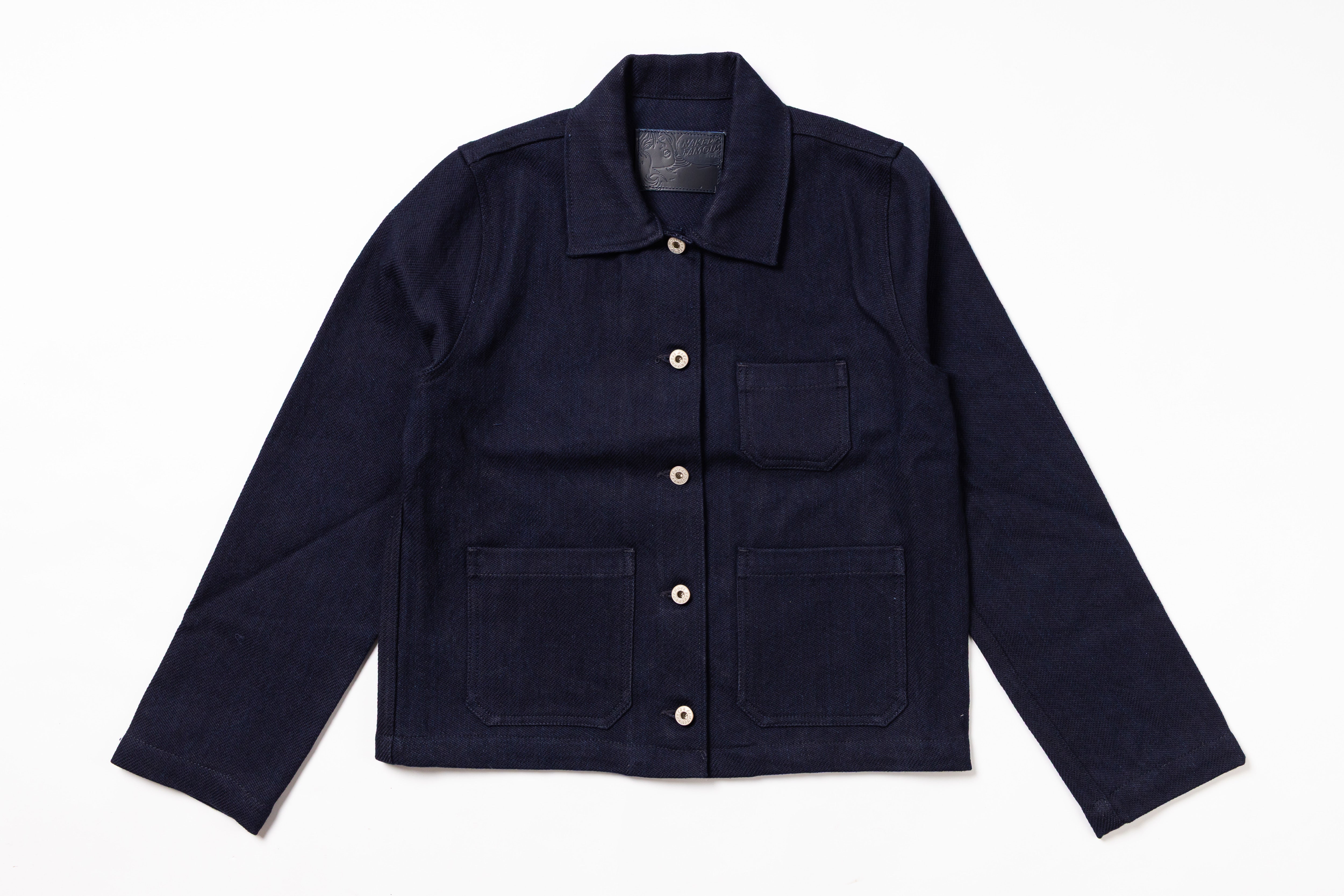 A dark navy blue corduroy utility jacket with a pointed collar, button front, and four front pockets, laid flat on a white background.