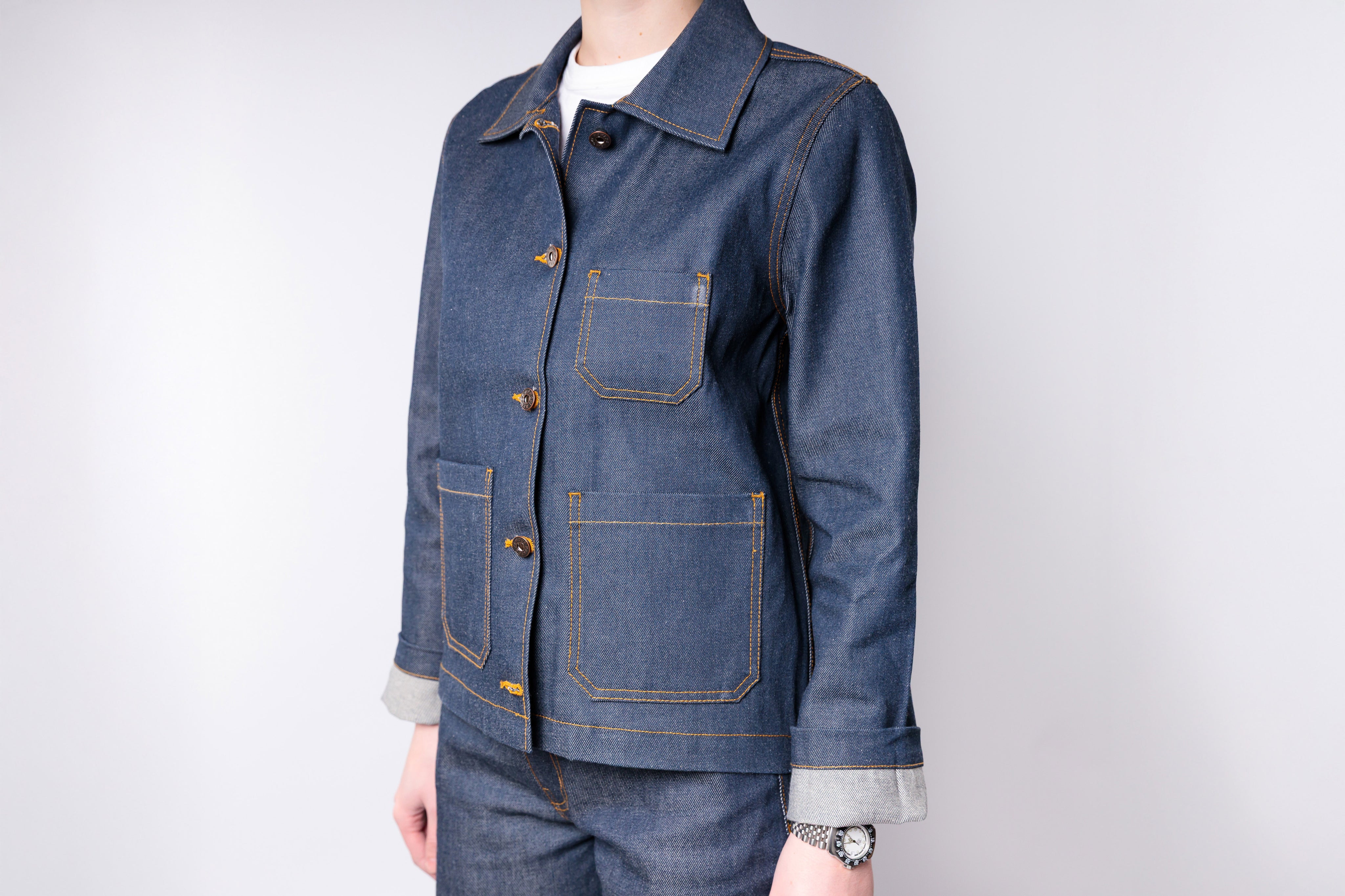 Denim jacket with rolled-up sleeves on a plain background