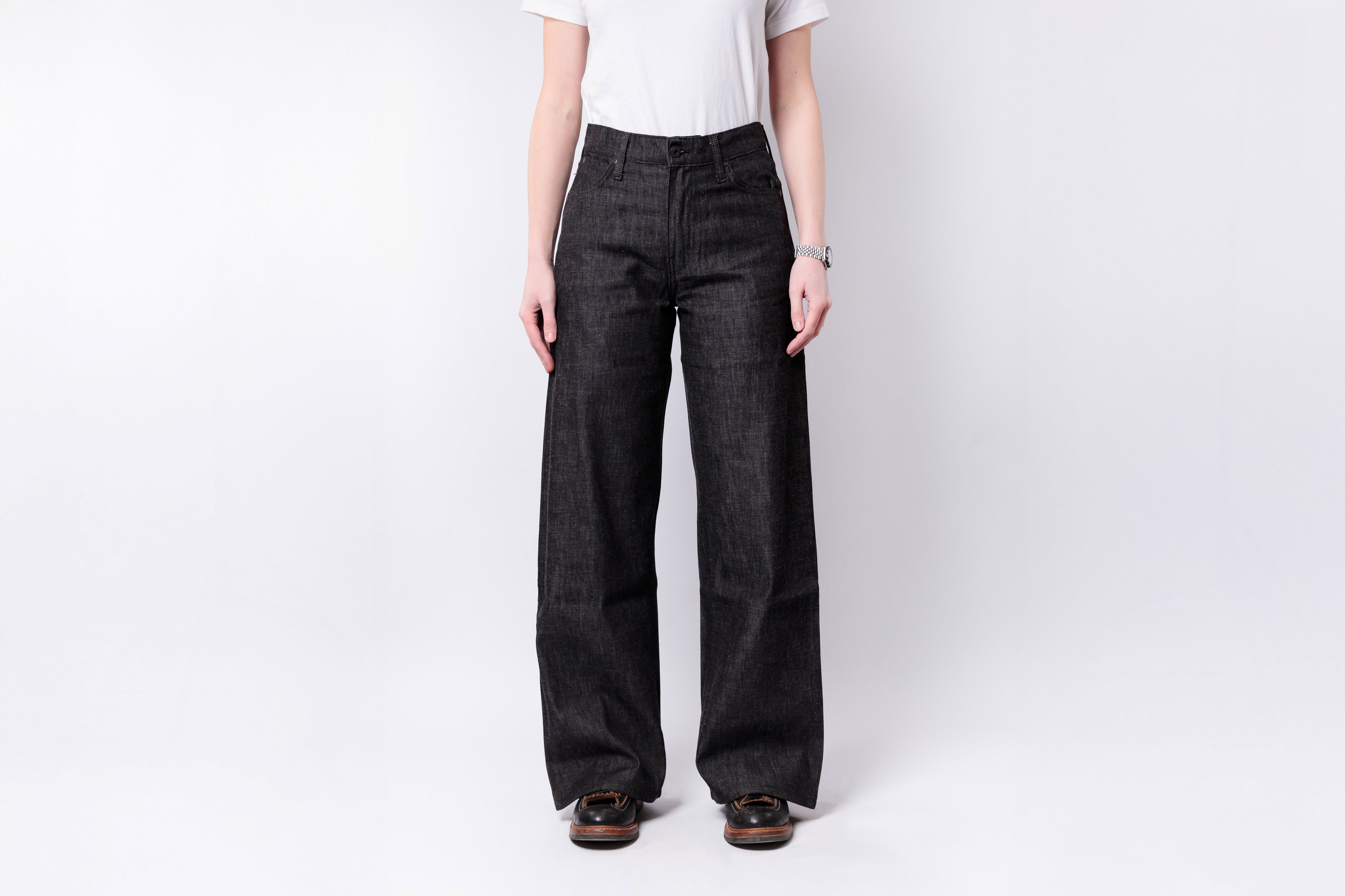 Person wearing black wide-leg jeans on a white background