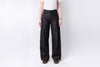 Person wearing black wide-leg jeans on a white background