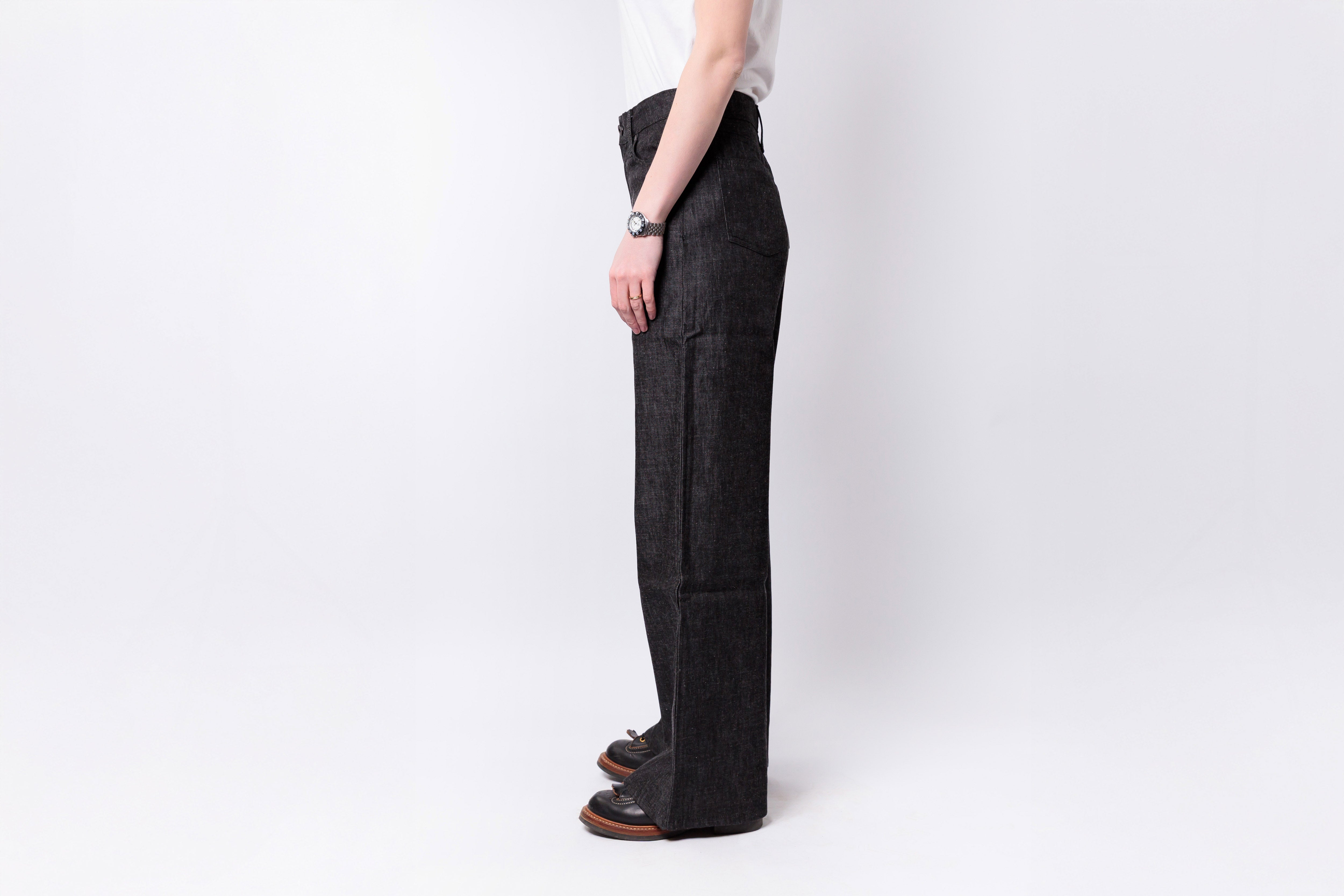 Person wearing dark gray pants on a white background