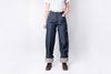 Person wearing blue jeans and a white shirt on a plain background