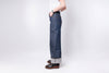 Person wearing blue jeans and a white shirt on a plain background