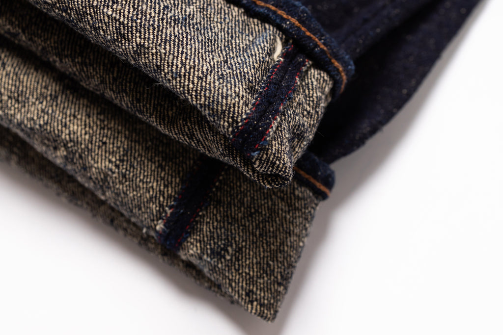 Folded denim jeans on a white background