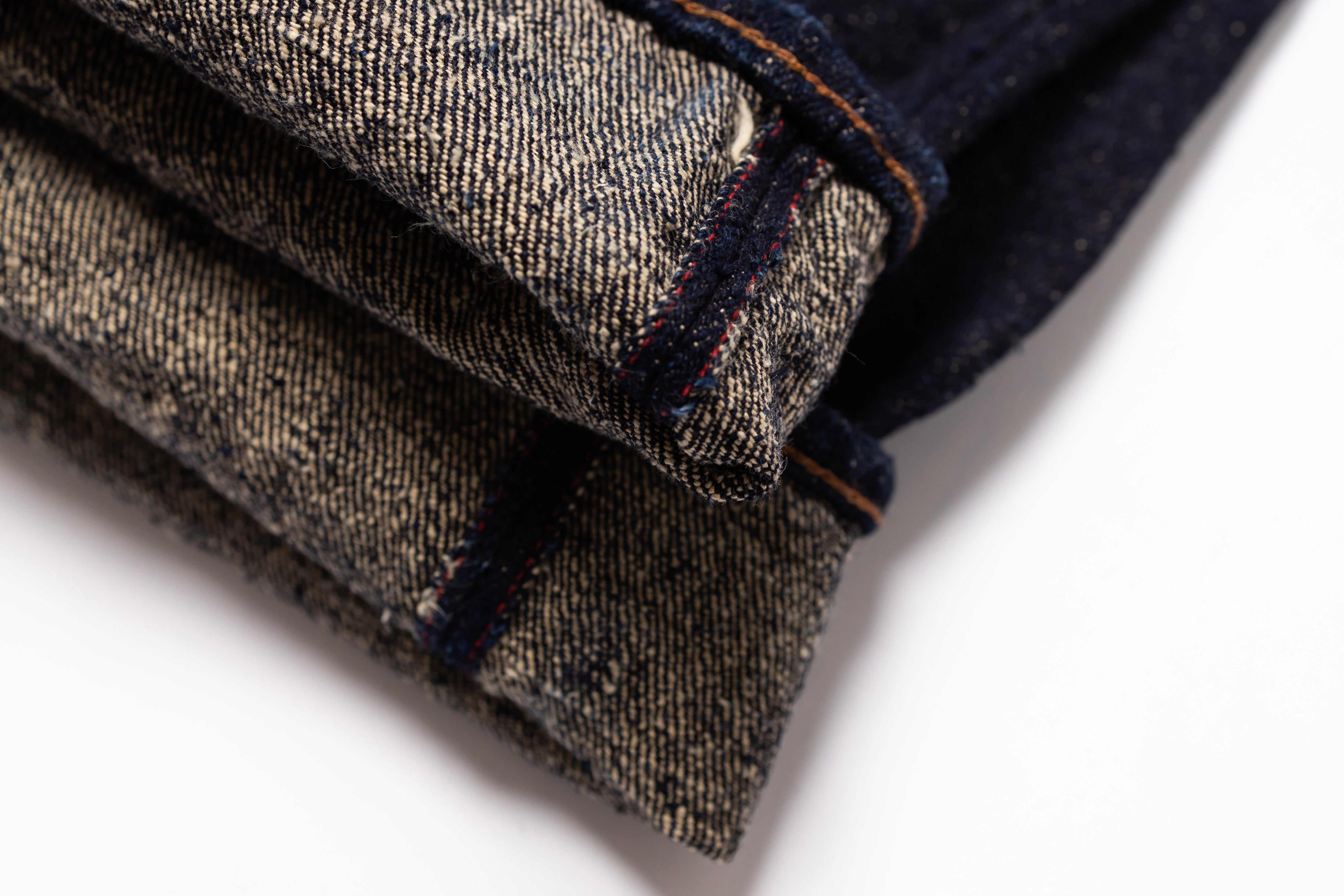 Folded denim jeans on a white background
