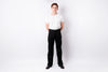 A man standing against a white studio background, wearing a plain white short-sleeve T-shirt, black pants, and black shoes.