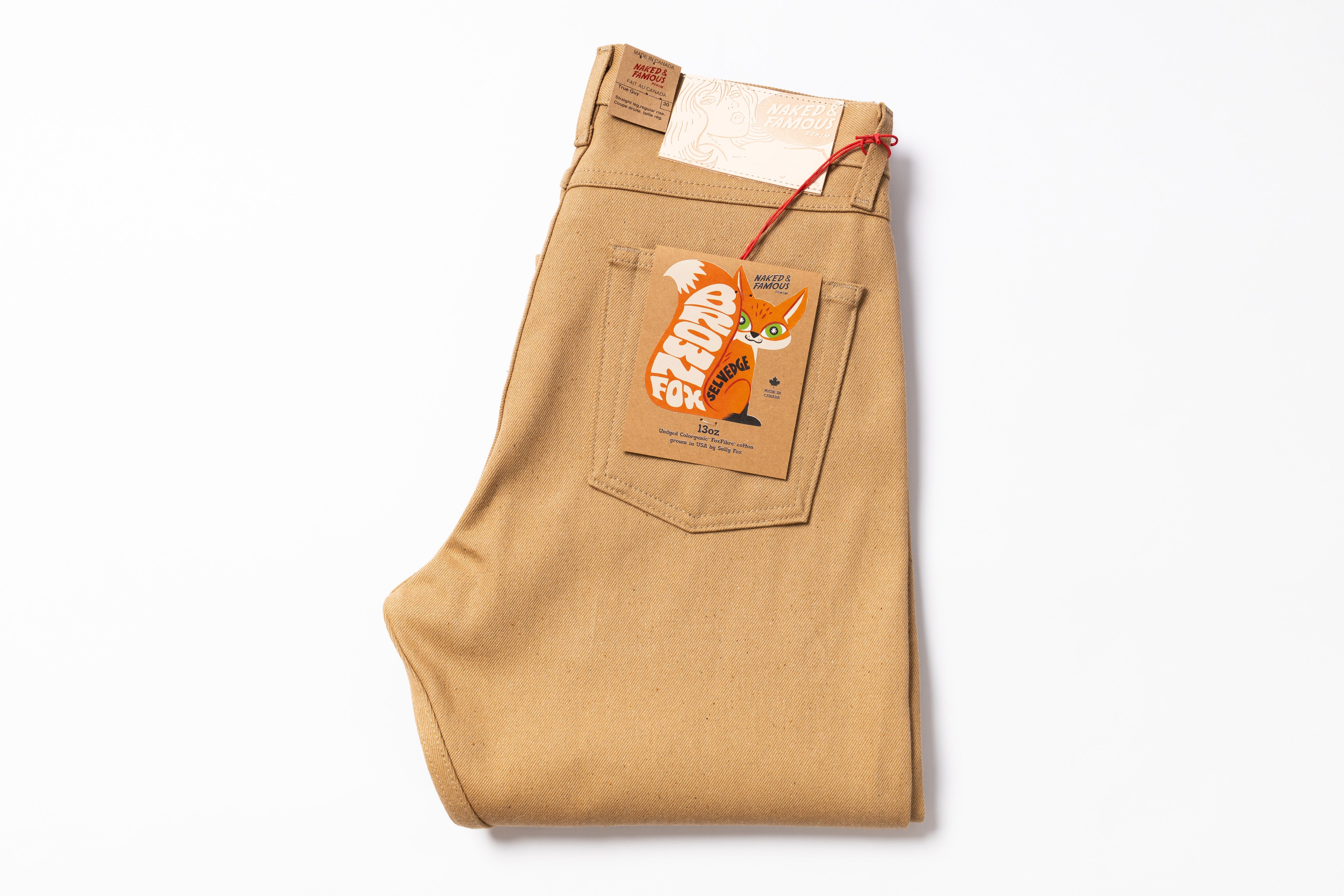 Beige pants with a brand tag on a white background