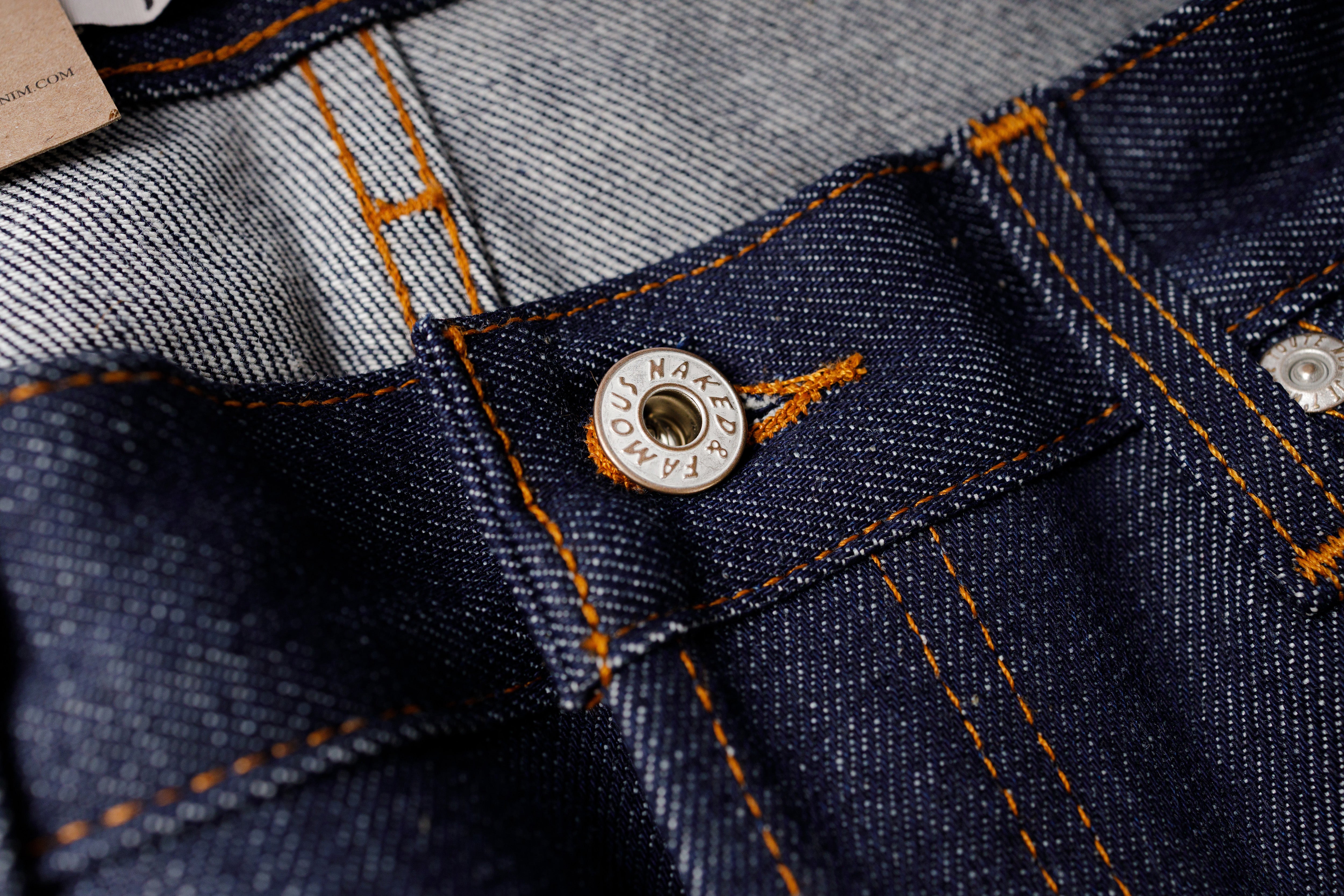 Close-up of a button on a denim fabric with brand name visible