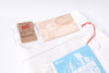 Naked & Famous bath salt packaging with a white drawstring bag on a light background