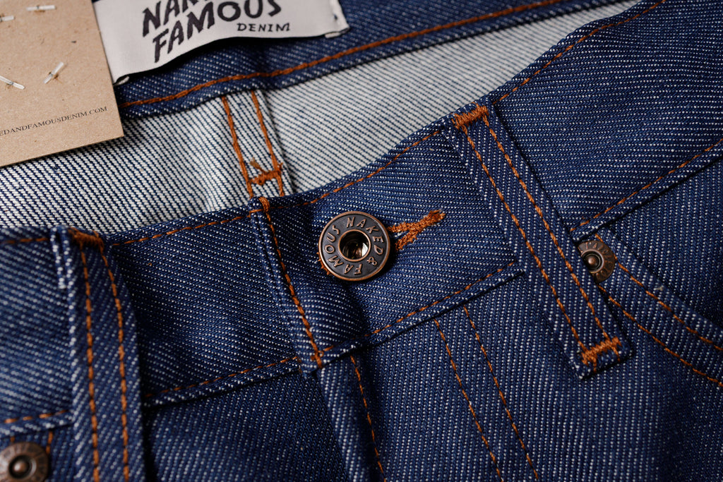 Close-up of blue denim fabric with a button 