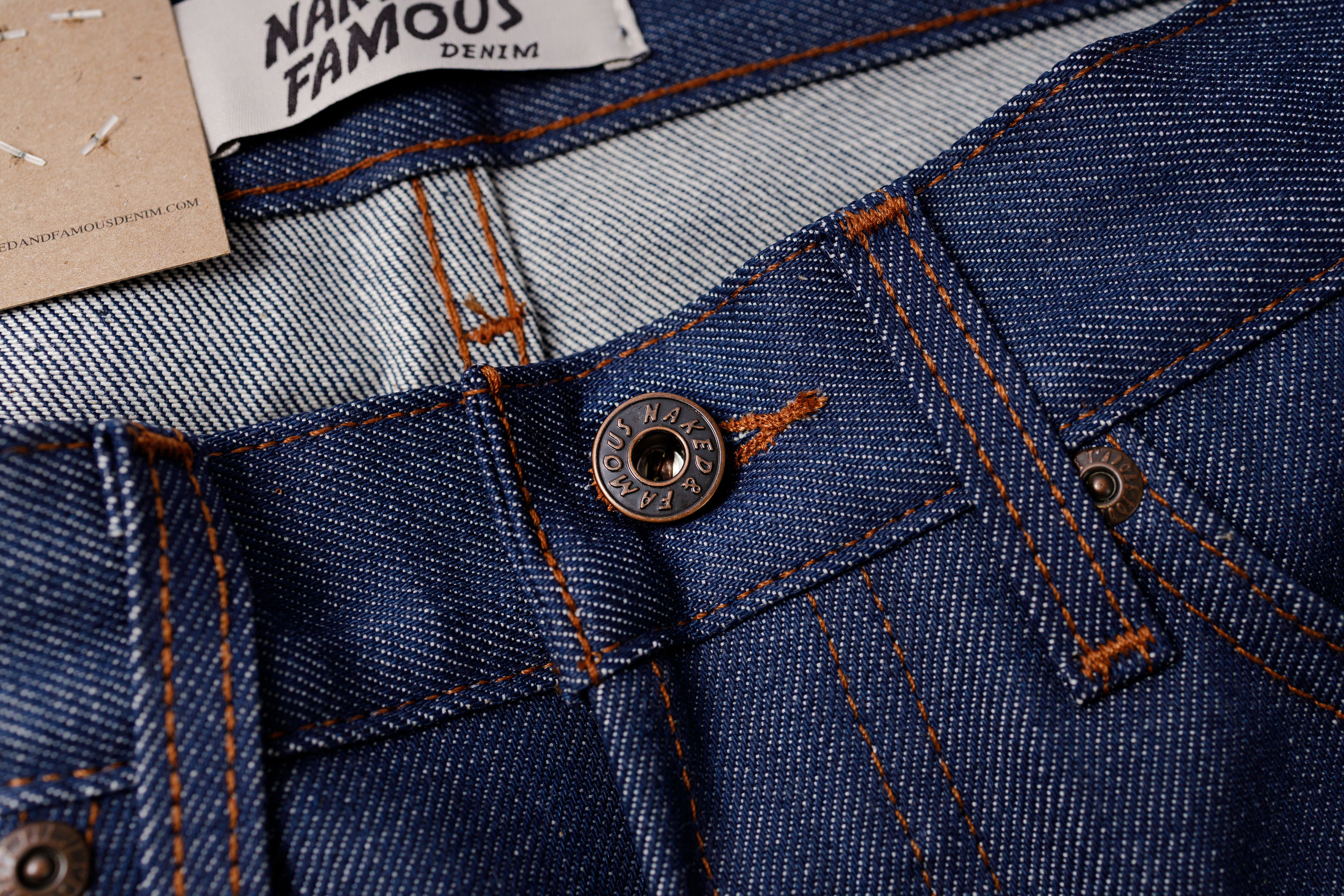 Close-up of blue denim fabric with a button 
