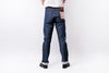 A person shown from the back wearing dark blue denim jeans with rolled cuffs, black shoes, and a white shirt against a plain white studio background.