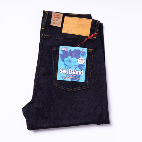 Folded pair of jeans with a 'Sea Island' label on a white background