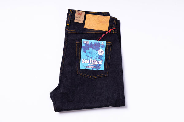 Folded pair of jeans with a 'Sea Island' label on a white background