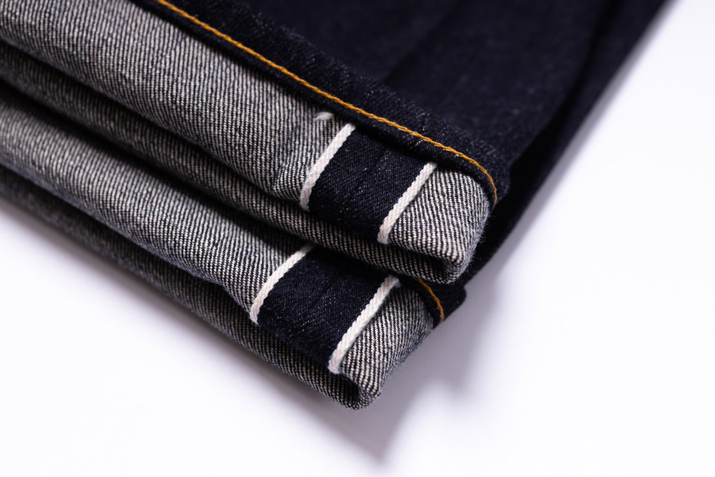 Folded denim jeans with a white background