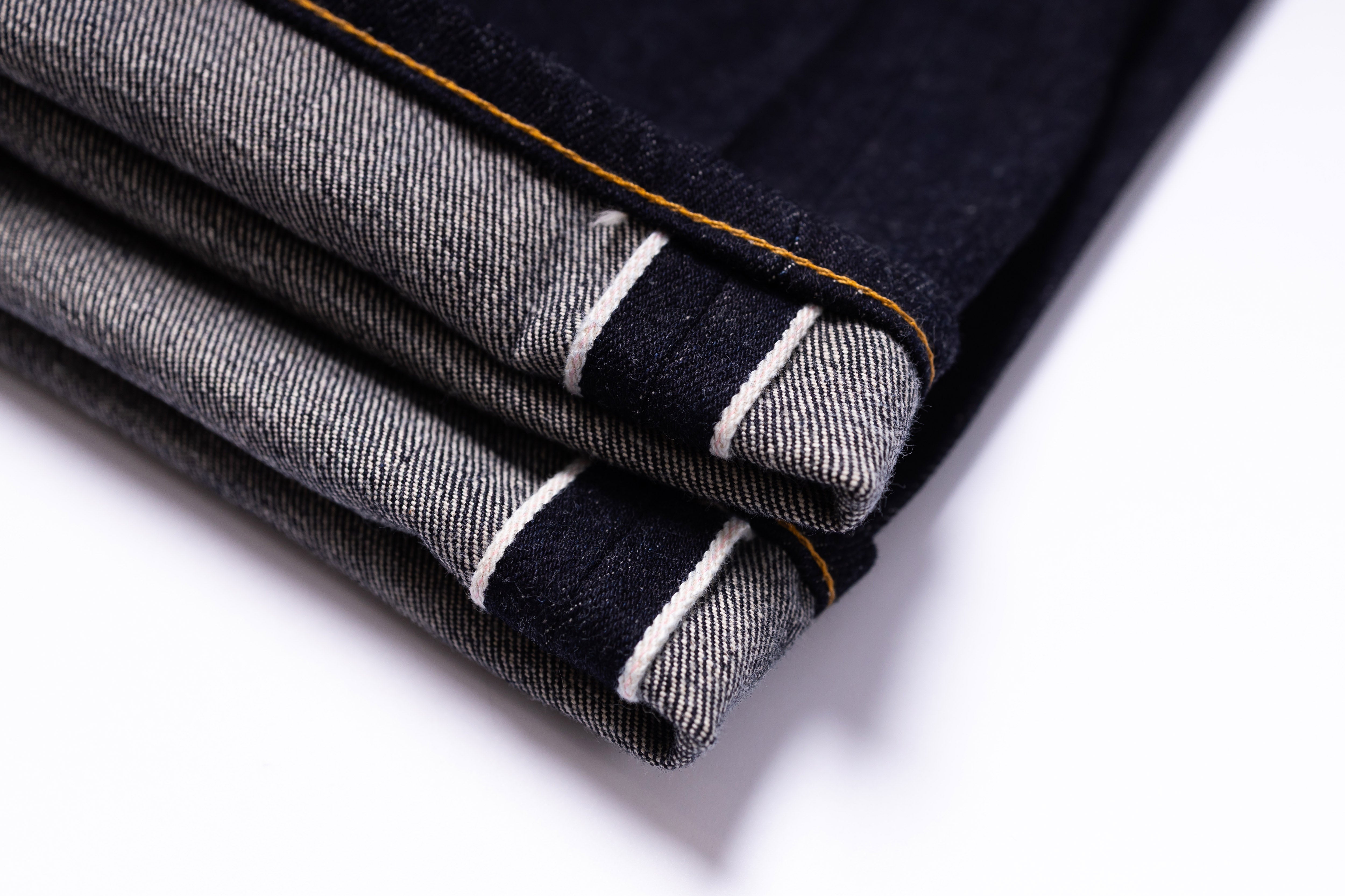 Folded denim jeans with a white background
