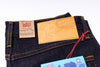 Close-up of a denim jeans label with 'Naked & Famous' branding on a white background
