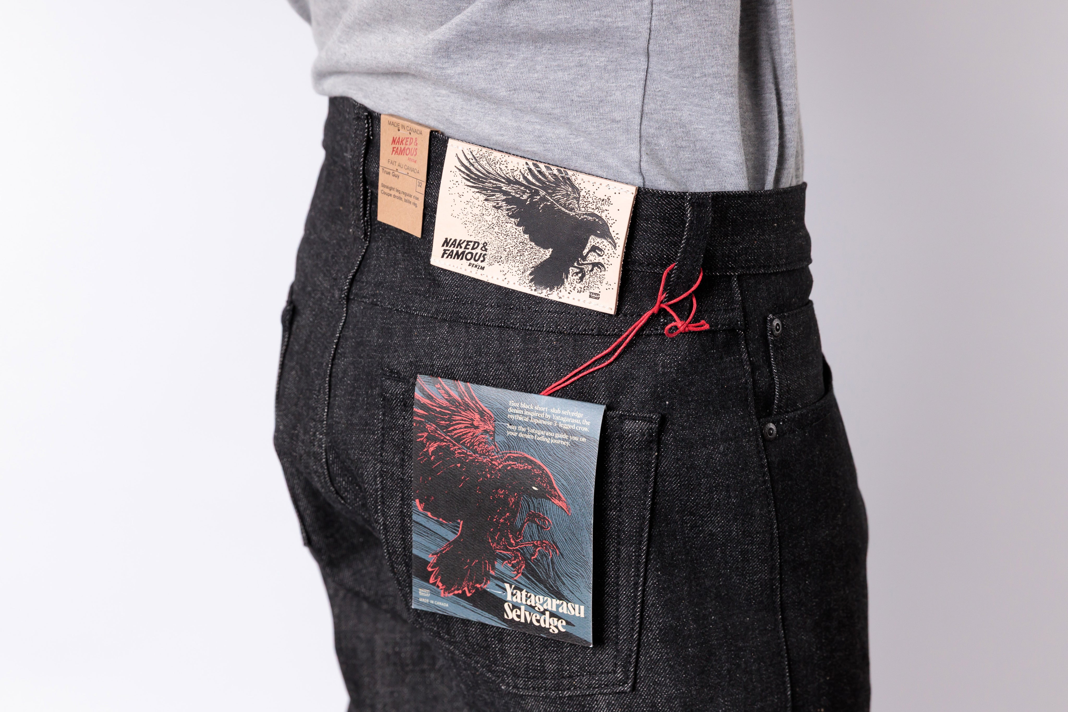 Person wearing black pants with printed labels on a gray background
