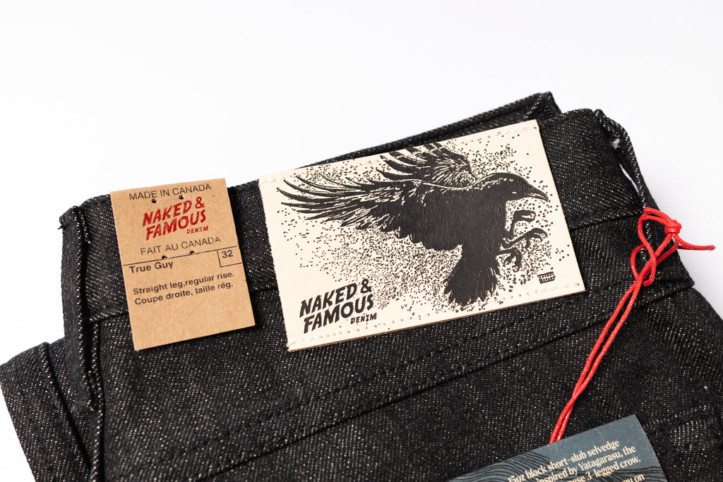 Naked & Famous jeans with a label and tag on a white background