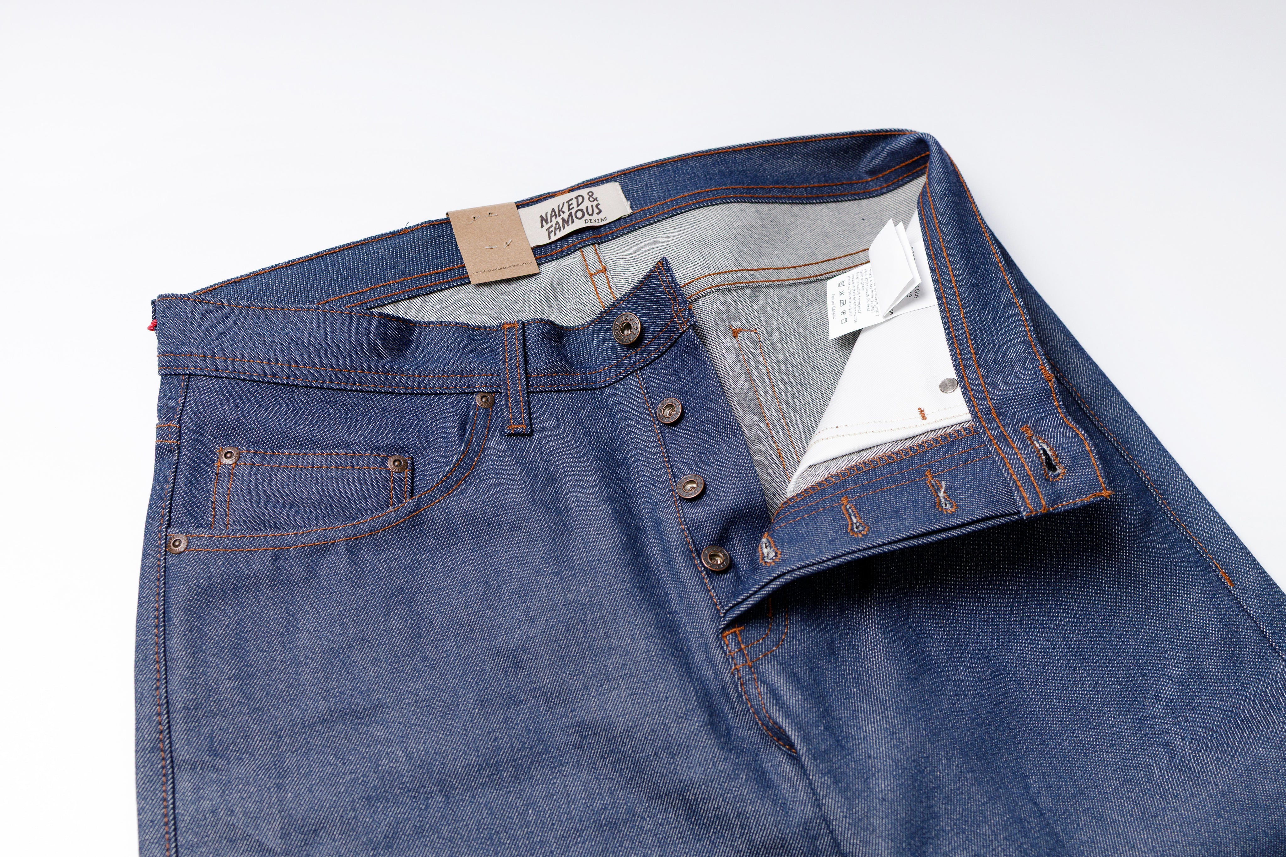 Blue denim jeans with a brand label on a white background